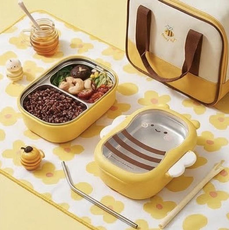 Pu&ograve; includere: Set per il pranzo a tema ape, con contenitori gialli e in acciaio inossidabile. Uno &egrave; rettangolare con scomparti, l'altro a forma di ape. Include borsa abbinata, barattolo di miele e accessori.