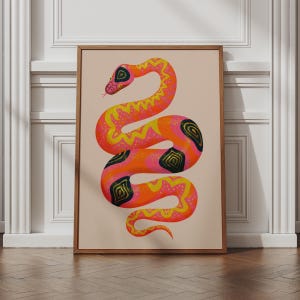 Könnte beinhalten: Ein gerahmter Kunstdruck mit einer stilisierten Schlangenillustration in leuchtenden Neon-Pink-, Orange- und Gelbtönen. Die Schlange hat einen gewundenen Körper, der mit gelben Zickzackmustern und dunkelgrünen ovalen Flecken auf beigem Grund verziert ist.