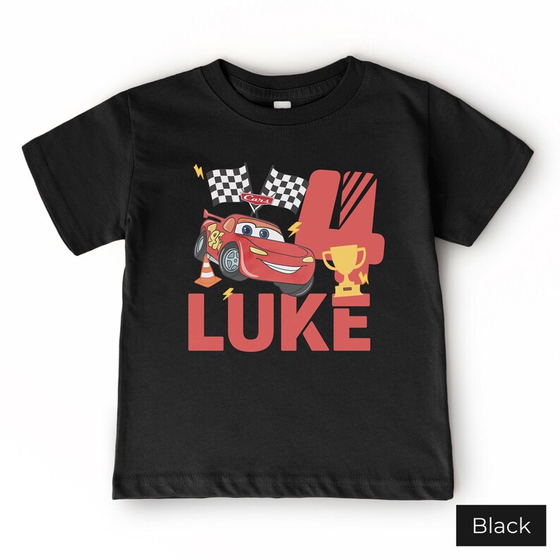 May include: A black short-sleeve t-shirt featuring a graphic of a red race car, two checkered flags, a gold trophy, an orange traffic cone, and the number 4. The name LUKE is printed in large red letters below the car and trophy graphic.