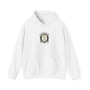 May include: White hooded sweatshirt with a front pocket and drawstring. The sweatshirt features a circular emblem with the words "QUIETLY ELITE" and "GOLF & LEISURE CLUB" in a green and black design. The emblem includes a golf club, a cocktail glass, and a golf ball.