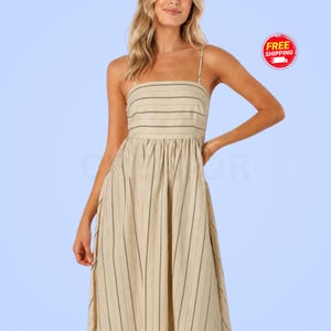 May include: A beige midi dress featuring thin spaghetti straps and a square neckline. The bodice has horizontal stripes, while the skirt displays vertical stripes in a darker shade. The dress is constructed with a fitted top and a flowing skirt.