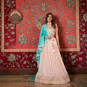 Lehenga Choli color pesca in georgette con dupatta color verde acqua, abito da sposa indiano con ricami a specchio, set da damigella d'onore di design con ricami a più fili.