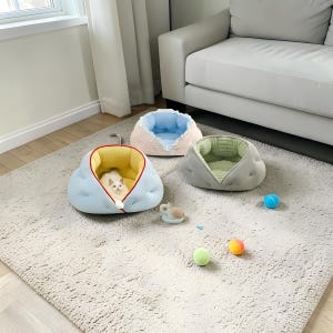 May include: Three pet beds in pastel colors sit on a neutral rug. One bed is light blue with a yellow interior, another is pink and blue, and the third is gray with a green interior. A white cat is inside the blue bed. Small toy balls are scattered around.