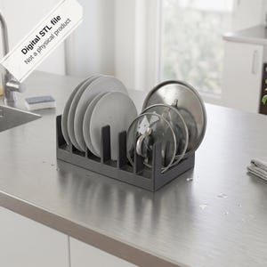 Può includere: Uno scolapiatti rettangolare grigio scuro con divisori verticali che contiene diversi piatti bianchi e coperchi in metallo. Un'etichetta bianca riporta il testo Digital STL file Not a physical product.