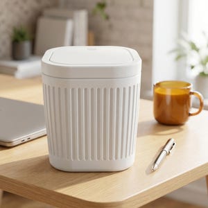 Op de afbeelding: Een witte, rechthoekige afvalbak met een verticaal geribbelde textuur aan de buitenkant en een plat, afneembaar deksel. De container heeft afgeronde hoeken en een strakke, effen afwerking, ontworpen voor op het bureau of kleine ruimtes.