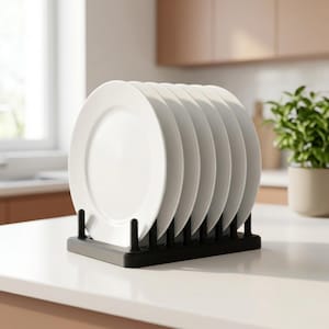 Puede incluir: Un escurridor de platos rectangular de color negro con varillas verticales que sostiene seis platos de cerámica blanca lisa en posición vertical. El soporte cuenta con una base resistente con ranuras espaciadas para organizar.