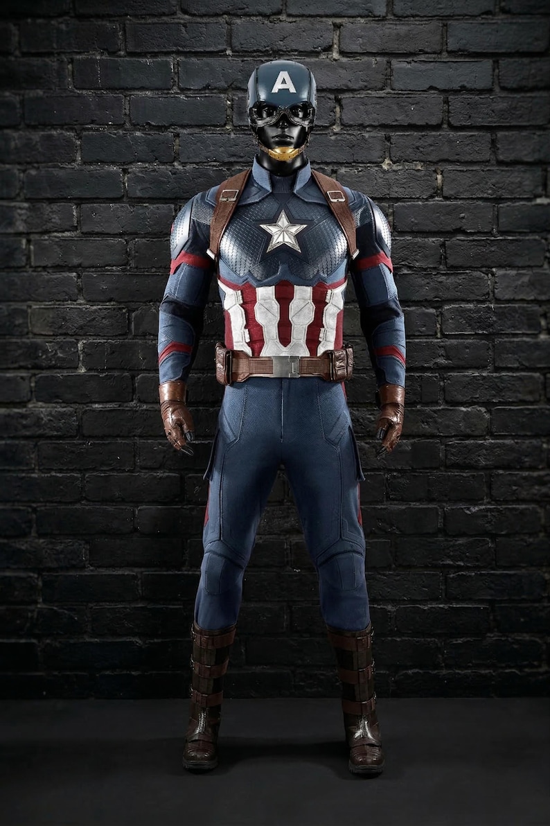 May include: A Captain America costume in blue and red. The outfit includes a helmet with the letter "A", a chest star, and brown leather details. The figure stands against a black brick wall. The costume is a replica.