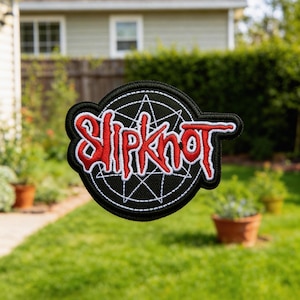 Puede incluir: Parche bordado en blanco y negro con el nombre de la banda "Slipknot" en rojo. El parche tiene un diseño circular con un patrón geométrico y un borde negro. Diseñado para coser en ropa o bolsos.