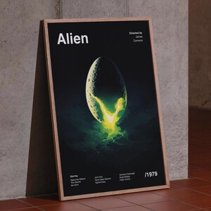 Peut inclure: Une affiche encadrée du film "Alien". L'affiche présente un fond noir avec le titre "Alien" en blanc. Un objet en forme d'œuf brille d'une lumière jaune et verte. L'affiche comprend le nom du réalisateur, l'année 1979 et la distribution.