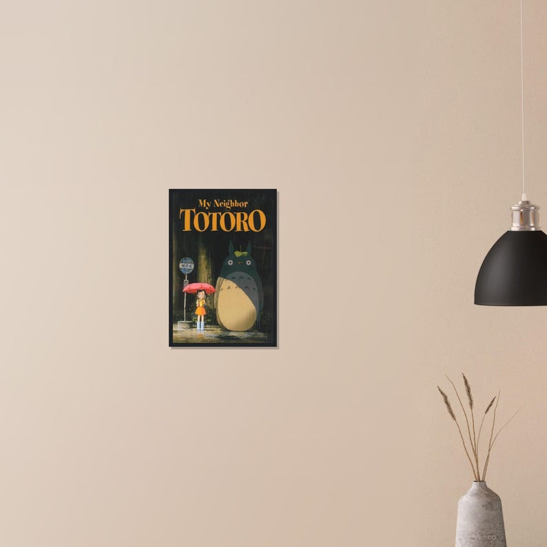 Pode incluir: Impress&atilde;o emoldurada de "Meu Vizinho Totoro" com texto dourado. A imagem mostra um grande personagem Totoro cinza e uma menina com um guarda-chuva vermelho. Um ponto de &ocirc;nibus &eacute; vis&iacute;vel ao fundo.