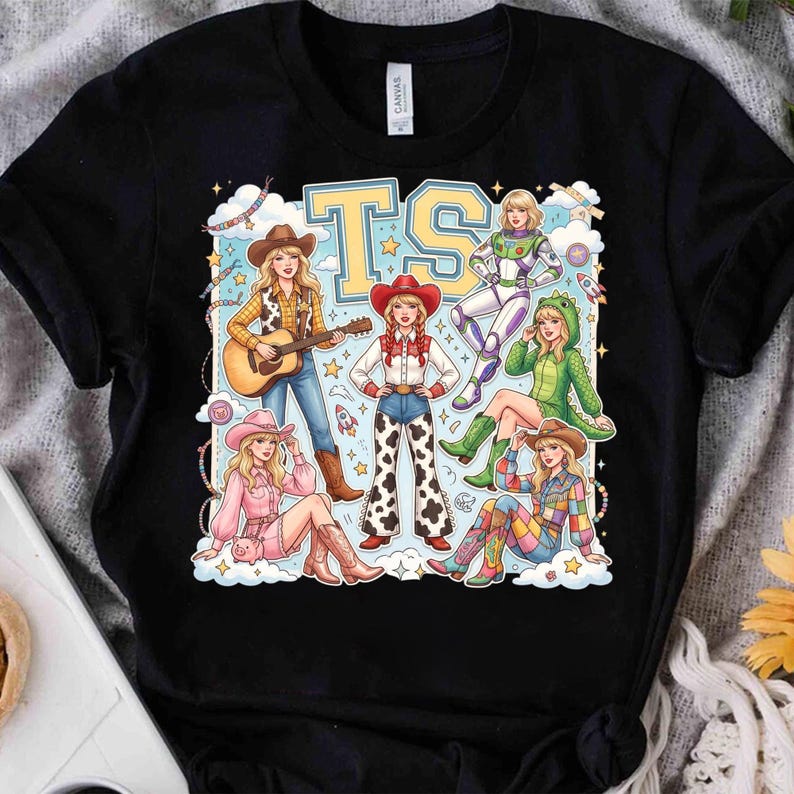 K&ouml;nnte beinhalten: Ein schwarzes Kurzarm-T-Shirt mit einem Grafikdruck von sechs illustrierten Figuren in verschiedenen Outfits, darunter eine Cowgirl mit Gitarre, ein Weltraum-Ranger und ein Dinosaurierkost&uuml;m, mit den gro&szlig;en gelben Buchstaben TS oben.