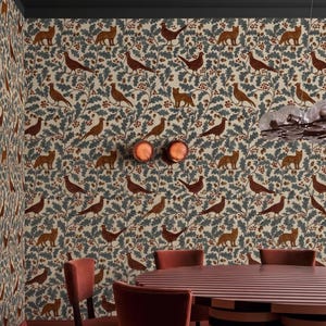 Puede incluir: Un comedor con papel pintado con un patrón repetido de zorros, pájaros y follaje en tonos marrón, azul y beige. La habitación incluye una mesa redonda y sillas de color marrón rojizo.