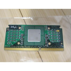 May include: A green and gold circuit board with the Intel logo. The board has a central silver square and numerous small components. The board is rectangular with gold connectors along the bottom edge.