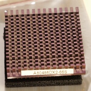 May include: A close-up of a purple and black computer component. The component has a grid-like pattern of small, square columns. The text "A80486DX2-66S" is printed on a small white label attached to the component.