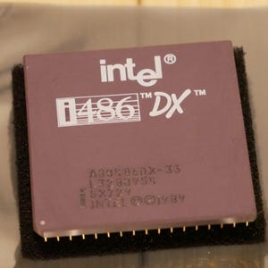 May include: A close-up of a vintage Intel i486 DX processor. The processor is a rectangular, mauve-colored component with gold pins. The Intel logo and "i486 DX" are printed in white. Additional text includes "A30186DX-33" and "©1989".