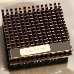 May include: A dark purple CPU heatsink with a grid of vertical fins. A label with the text "486DX-2/66" is affixed to the side. The heatsink is designed to dissipate heat from a computer processor.