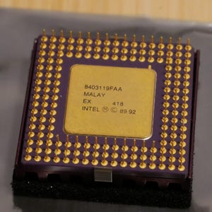 May include: A white ceramic mug with a black handle and the text "But First, Coffee" in a black, handwritten-style font. The mug is on a white surface.