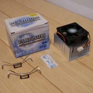 May include: A computer CPU cooler kit with a black fan, silver heat sink, and mounting brackets. The box reads "PLATINUM PC Thermal Total Solution". Includes a small packet of thermal paste.