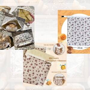 May include: A rectangular bread bag made of beige cotton fabric with a small dark red floral pattern. The bag features a white top closure with a black plastic buckle. It measures 32 cm in width and 43 cm in height. The interior is lined with yellow beeswax.
