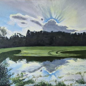 May include: An oil painting depicts a serene landscape with a reflective lake. The sky features dramatic clouds and sun rays. The foreground shows green grass and water, with trees lining the horizon. The artwork evokes a sense of peace.