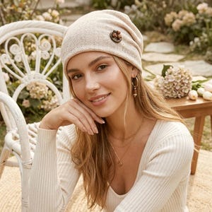 Puede incluir: Una taza de cerámica blanca con un asa negra y el texto "But First, Coffee" en negrita negra. La taza se encuentra sobre un fondo borroso, sugiriendo un ambiente acogedor.