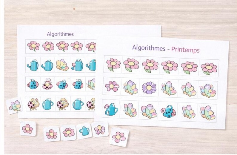 Peut inclure: Deux feuilles de papier blanc avec le mot "Algorithmes" imprim&eacute;, pr&eacute;sentant des rang&eacute;es d'illustrations color&eacute;es de fleurs, d'arrosoirs, de papillons et de coccinelles. De petits carreaux assortis sont &eacute;parpill&eacute;s en dessous.