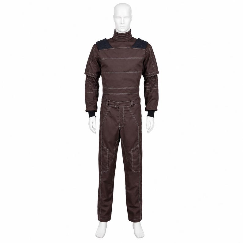 May include: A dark brown jumpsuit featuring a high mock neck collar, horizontal white stitching across the chest, and dark navy shoulder panels. The long sleeves have black ribbed cuffs, and the trousers include reinforced knee sections.