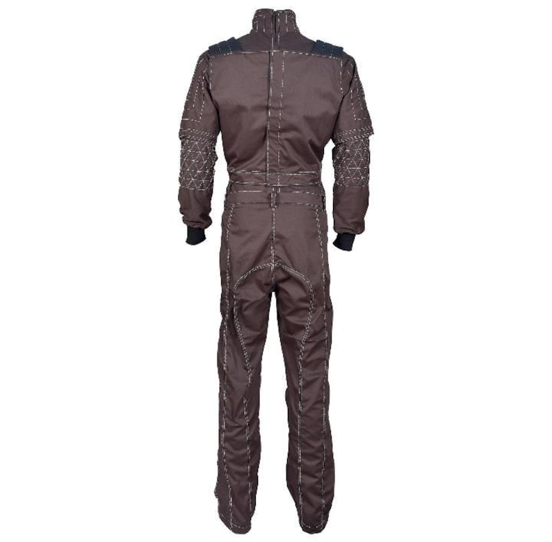May include: A dark brown jumpsuit featuring a high collar, long sleeves with black cuffs, and a structured design. The garment is accented with prominent light-colored stitching along the seams and textured geometric patterns on the shoulders.