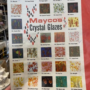 May include: A Mayco's Crystal Glazes color chart featuring a grid of 30 square ceramic glaze samples with various multi-colored patterns and textures. Each sample is numbered and labeled with names like Mexicali, Firecracker, and Mystic Jade.