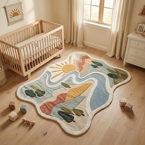 May include: An irregularly shaped area rug featuring a landscape design with a yellow sun, blue river, terracotta mountains, and green trees. The rug has a textured surface with cream-coloured borders and is placed on a light wood floor.