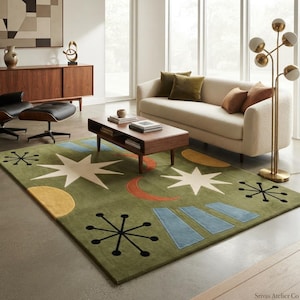May include: A rectangular area rug featuring an olive green background with a repeating pattern of white stars, orange crescent moons, yellow semi-circles, light blue trapezoids, and black starburst shapes with dots at the ends of the lines.