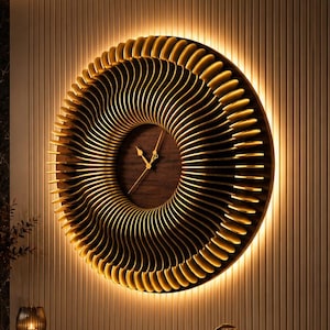 May include: A large, round, wooden wall clock with a unique, layered design. The clock features a dark wood center with gold-toned hands and a surrounding spiral pattern. The clock is illuminated with warm lighting, creating a striking visual effect. The clock is mounted on a light-colored wall.