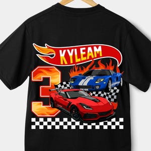 May include: Black t-shirt with a red and blue race car design, the name "KYLEAM" on a banner, and the number "3" with flames. A checkered flag design is at the bottom of the shirt.
