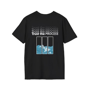 Puede incluir: Camiseta negra con el texto "Trust the Process" en blanco y gris. La camiseta presenta un gráfico de olas azules dentro de tres rectángulos verticales.