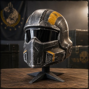 Op de afbeelding: Een verweerde zwart-gele helm met vizier, gepresenteerd op een zwarte standaard. De helm heeft gele strepen en accenten, met een versleten uiterlijk. De achtergrond omvat een vlag met een cirkelvormig embleem en opslagcontainers.