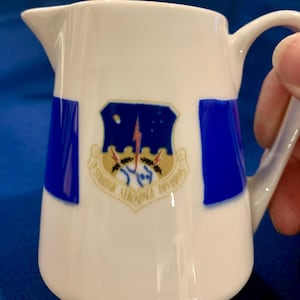 May include: A set of three ceramic mugs with a speckled, matte finish. The mugs are in shades of cream, light gray, and dark gray. Each mug has a simple, minimalist design, perfect for coffee or tea.
