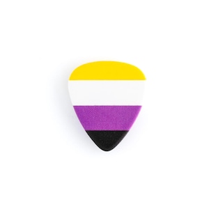 May include: A guitar pick with a non-binary pride flag design. The pick features horizontal stripes in yellow, white, purple, and black. The pick is teardrop-shaped and set against a white background.