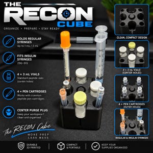 May include: A black, square, 3D-printed Recon Cube organizer featuring multiple circular slots for medical supplies. It holds various items including clear glass vials with colored caps, a syringe with an orange cap, and a clear syringe.
