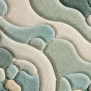 May include: Close-up of a textured rug with a pattern of organic shapes in shades of green, blue, and cream. The rug's design features rounded, flowing forms, creating a soft, tactile appearance. A decorative home decor item.