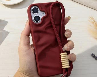 Funda para teléfono con textura mate arrugada y correa de muñeca para modelos de iPhone.