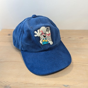 Könnte beinhalten: Blaue Baseballkappe mit gebogenem Schirm. Auf der Kappe ist ein gestickter Cartoon-Maus-Charakter auf der Vorderseite abgebildet. Die Maus hat ein weißes Gesicht, rosa Ohren und trägt blaue Latzhosen. Die Kappe ist aus weichem Stoff.