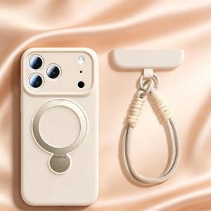 May include: A cream-colored phone case with a circular metal ring and a matching wrist strap. The case has three camera lenses and a flash. The wrist strap is made of a woven beige material and a matching cord.