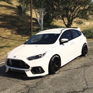 Peut inclure: Une voiture blanche Ford Focus RS à hayon avec des roues et des pneus noirs. La voiture est garée sur une route asphaltée fissurée avec une colline herbeuse en arrière-plan. Les pneus ont des lettrages blancs.