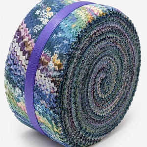 May include: A tightly wound roll of fabric strips featuring a variety of floral and geometric patterns in shades of blue, green, purple, and yellow. The roll is secured by a smooth, solid purple ribbon wrapped around the center of the fabric stack.