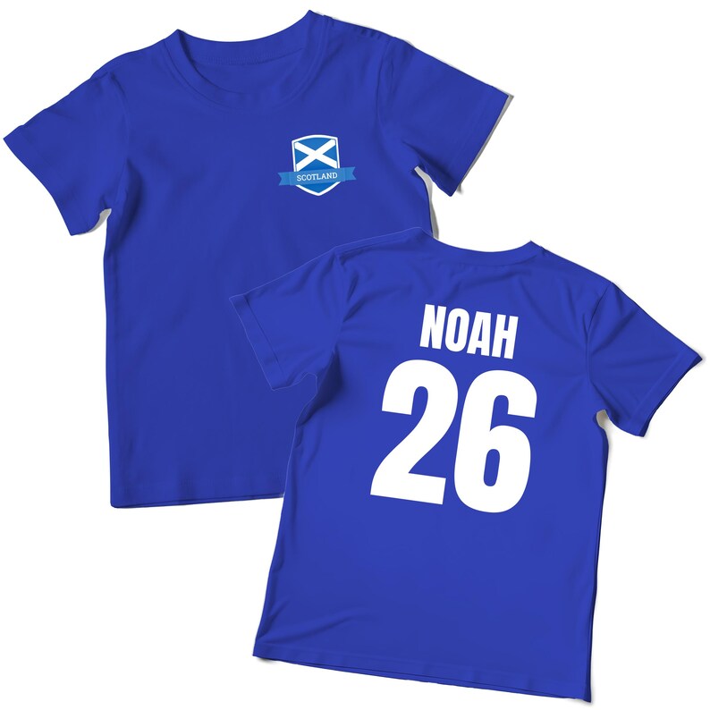 Puede incluir: Dos camisetas azules. Una camiseta tiene un peque&ntilde;o emblema con la bandera escocesa y la palabra "Scotland". La otra camiseta tiene el nombre "NOAH" y el n&uacute;mero "26" impresos en blanco en la espalda.