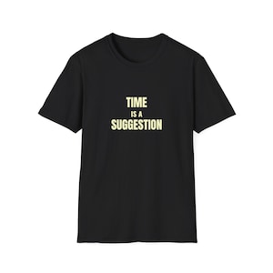 Puede incluir: Camiseta negra de cuello redondo con la frase "TIME IS A SUGGESTION" en amarillo claro. La camiseta de manga corta tiene un corte clásico, ideal para el uso diario.