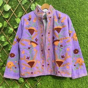 Peut inclure: Une tasse en céramique blanche avec une anse noire et le texte "But First, Coffee" en noir, dans une police manuscrite. La tasse est posée sur une surface blanche.