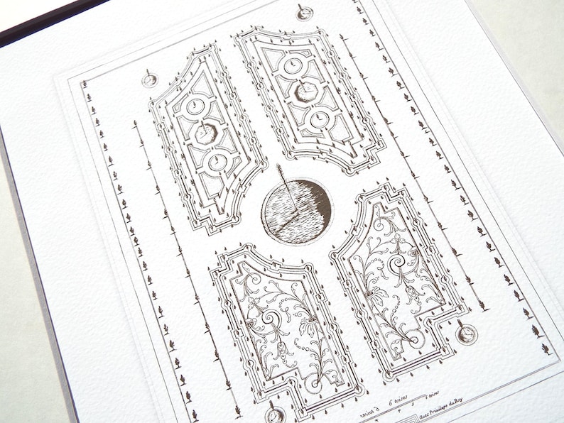 May include: A black and white line drawing of a formal garden design. The design features a central circular area surrounded by four rectangular areas with intricate patterns. The drawing is on a white background.