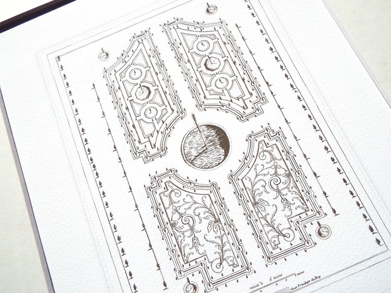 May include: A black and white line drawing of a formal garden design. The design features a central circular area surrounded by four rectangular areas with intricate patterns. The drawing is on a white background.