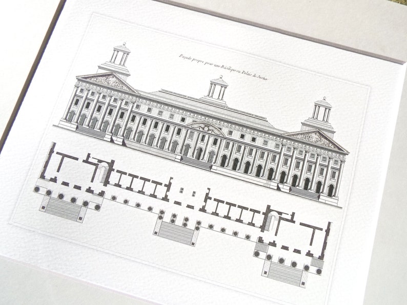 May include: Black and white architectural print of a building facade and floor plan. The print features detailed line drawings of a classical building with columns, windows, and decorative elements. The text at the top reads "Fa&ccedil;ade propose pour un Biblioth&egrave;que au Palais de Justice."